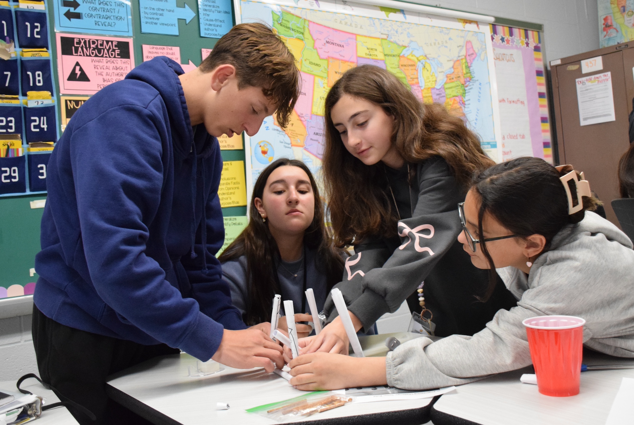 students playing with paper straws at desk